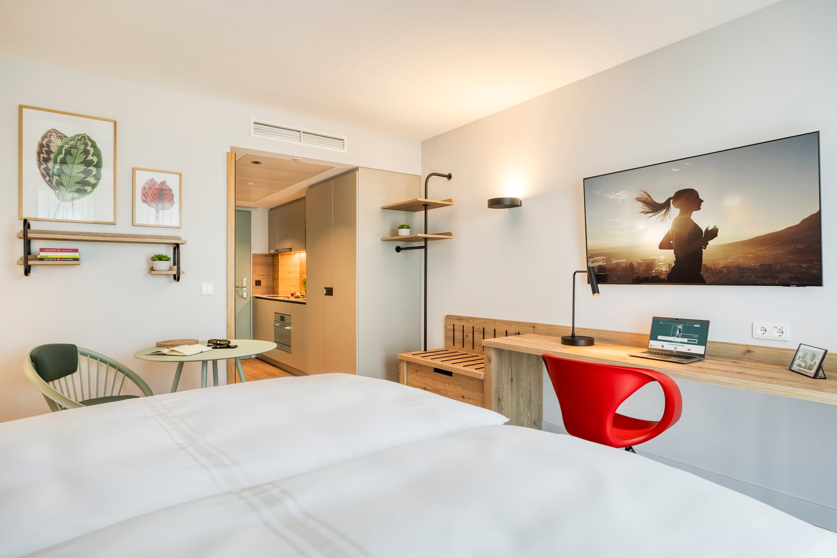 Studio mit einem Doppelbett, einem Fernseher mit Chromecast und einem Schreibtischbereich