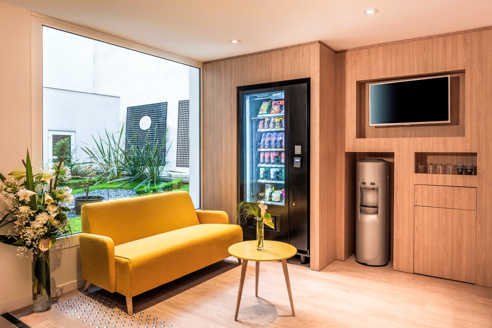 Lounge area of our apart hotel in Paris 18 equipped with a vending machine and a television