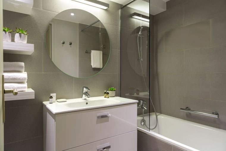 Badezimmer eines Studios mit Badewanne/Dusche, Toilettenartikeln und Handtüchern, wohnen auf Zeit in Paris 13