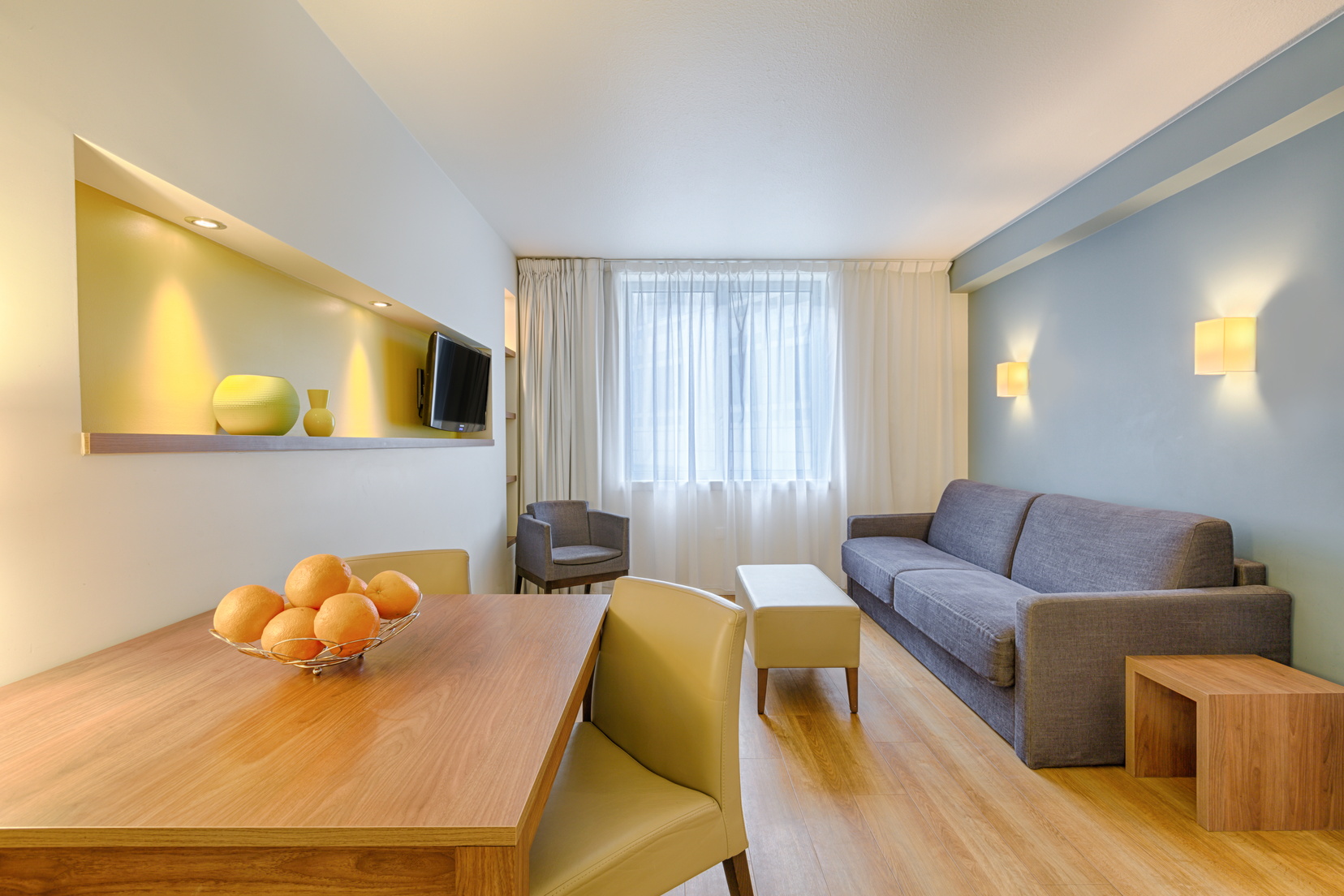 Wohnzimmer eines Apartment mit 1 Schlafzimmer mit Esstisch, Fernseher und Schlafsofa, wohnen auf Zeit in Paris 13