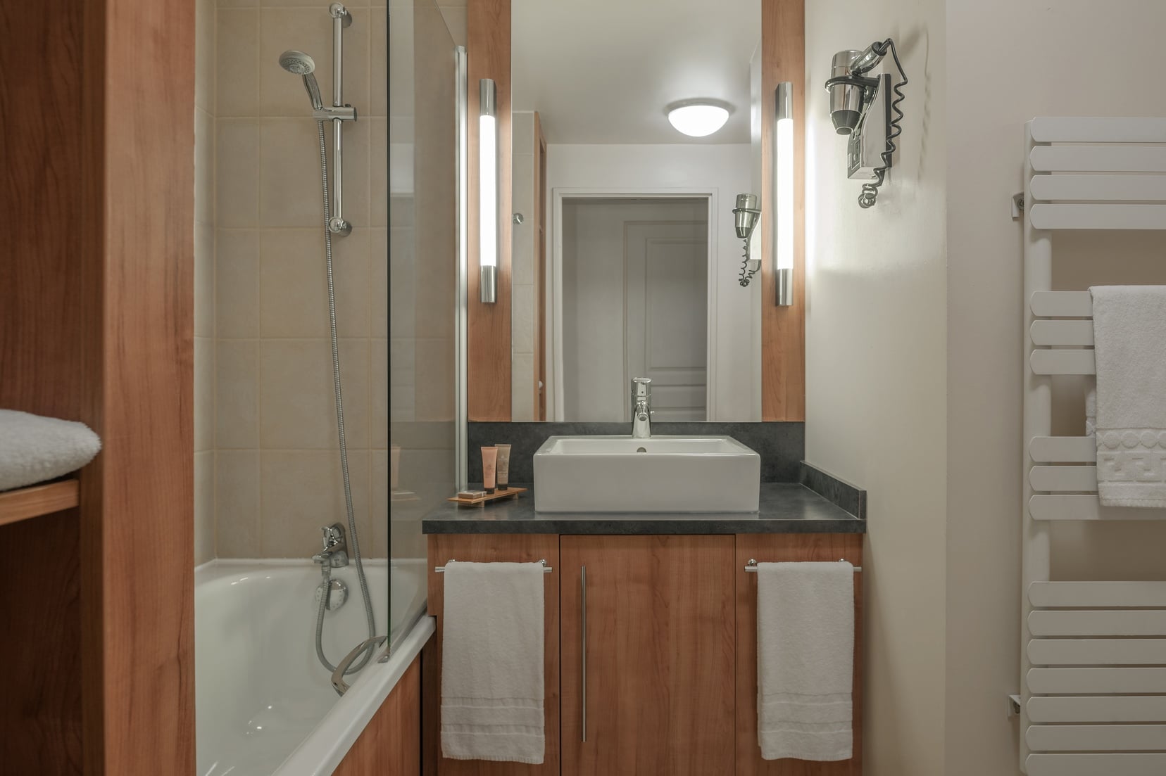 Salle de bain d'un Studio équipée d'un combiné baignoire/douche et d'articles de toilette, appart hotel Paris 6