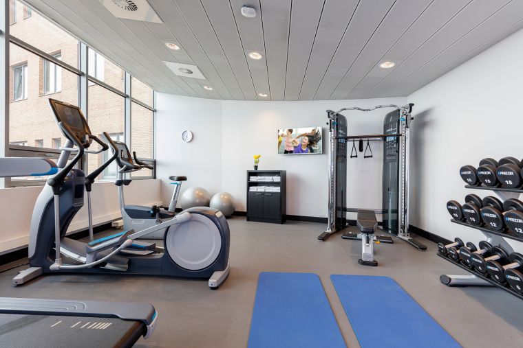 Gym with treadmills, weights, weight bench and elliptical bikes, apart hotel Amsterdam