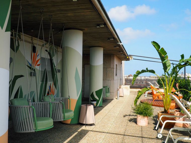 Terrace with sun loungers, sofas and wicker chairs with panoramic views of Barcelona, apart hotel Barcelona