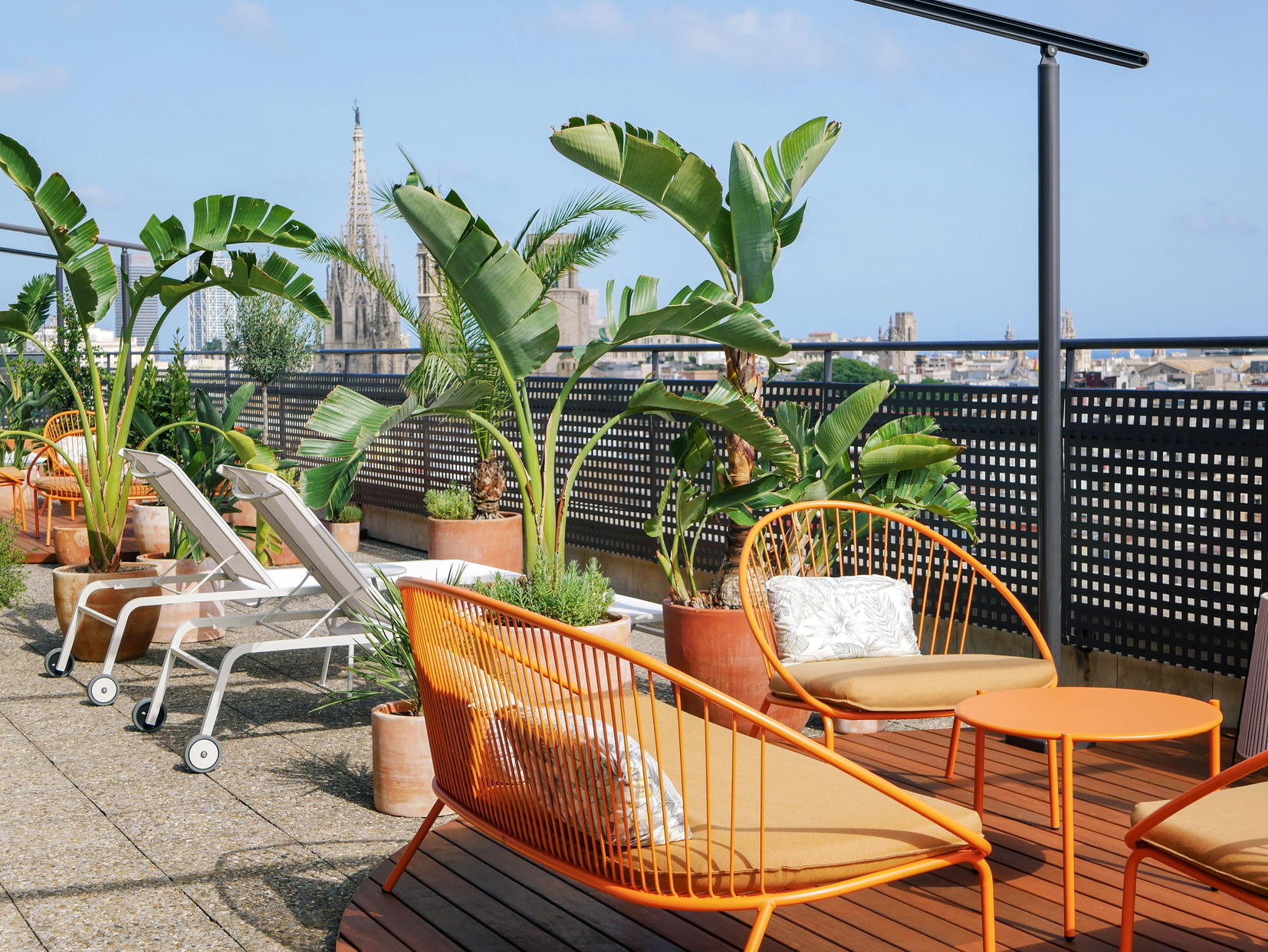 Terrace with sun loungers, sofas and wicker chairs with panoramic views of Barcelona, apart hotel Barcelona