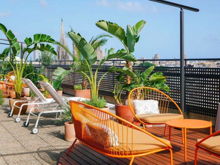 Terrace with sun loungers, sofas and wicker chairs with panoramic views of Barcelona, apart hotel Barcelona