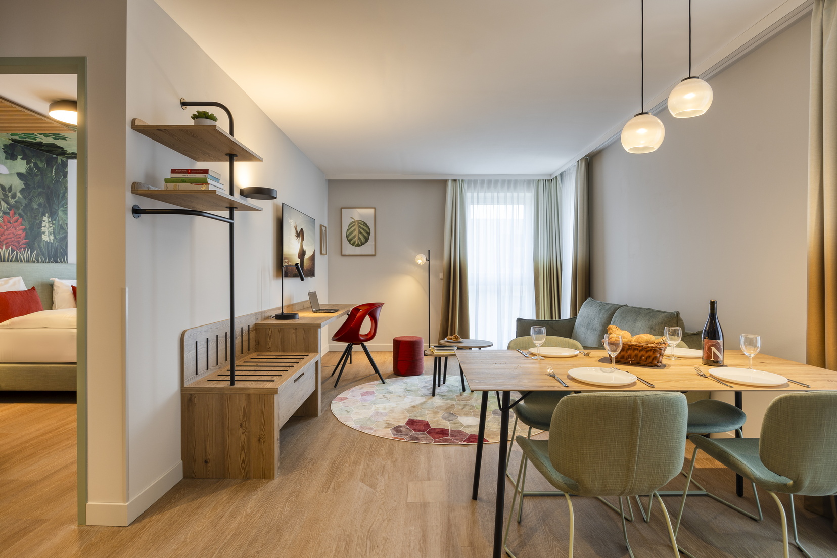 Living room of a One-Bedroom Executive Apartment with a sofa bed, desk, and dining area