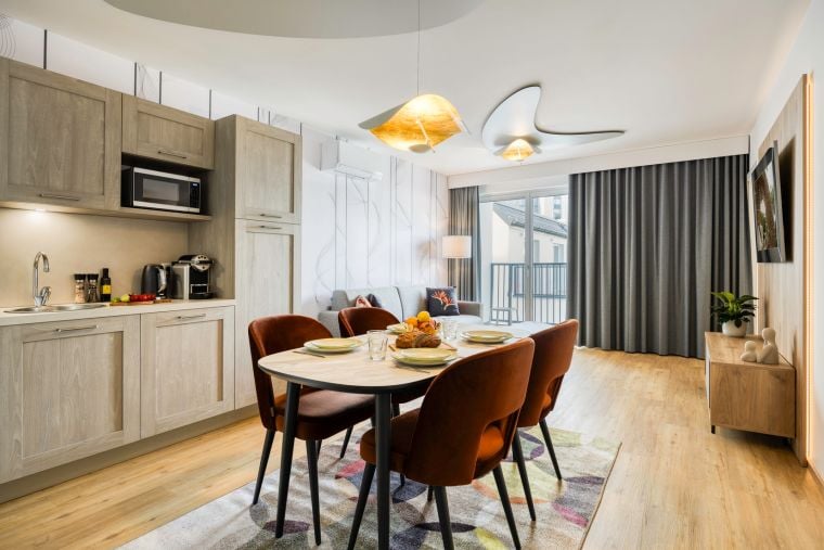 Living room of a 2-Bedroom Apartment equipped with a kitchen, a sofa bed, and a TV with Chromecast