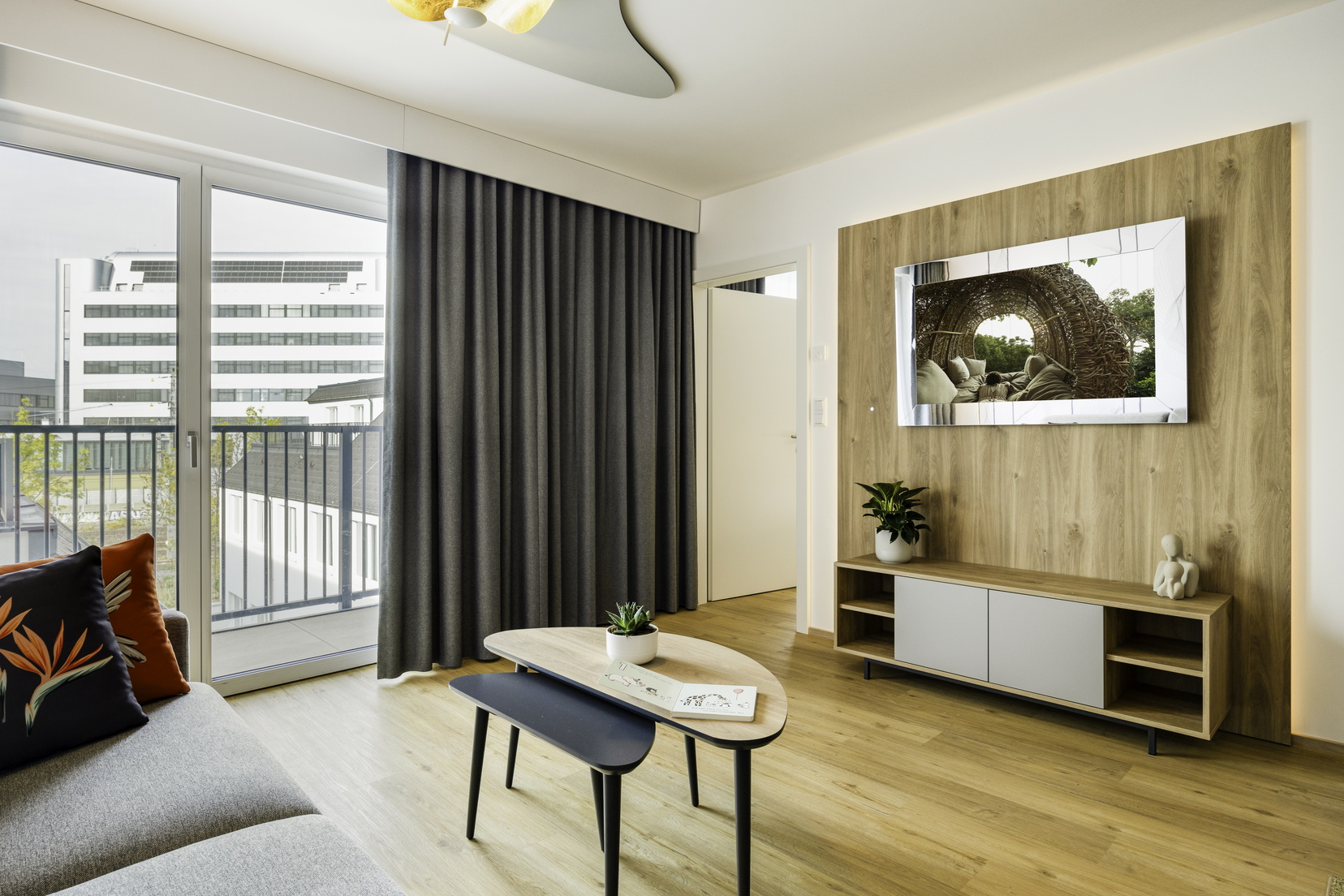 Living room of a 2-Bedroom Apartment equipped with a kitchen, a sofa bed, and a TV with Chromecast