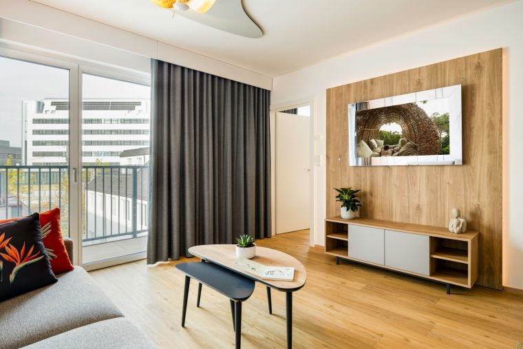 Living room of a 2-Bedroom Apartment equipped with a kitchen, a sofa bed, and a TV with Chromecast
