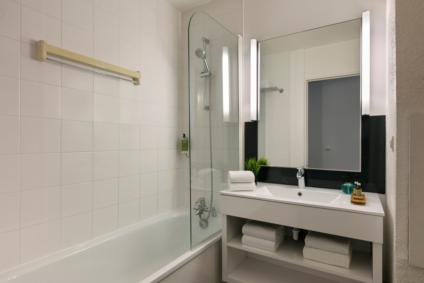 Bathroom of a Studio equipped with a bath/shower and towels, apart hotel Paris 13