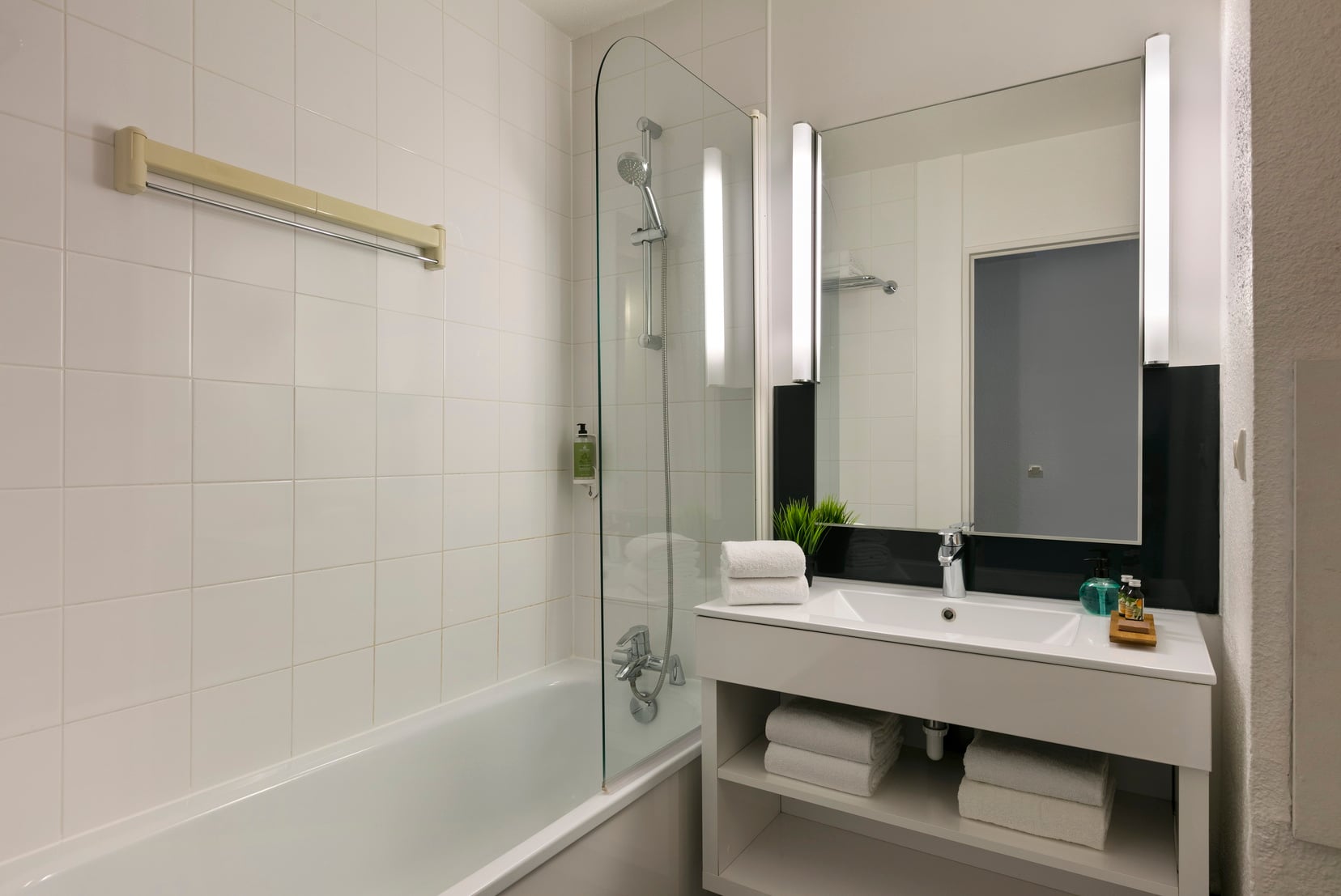 Salle de bain d'un Studio équipée d'un combiné baignoire/douche et de serviettes, appart hotel Paris 13