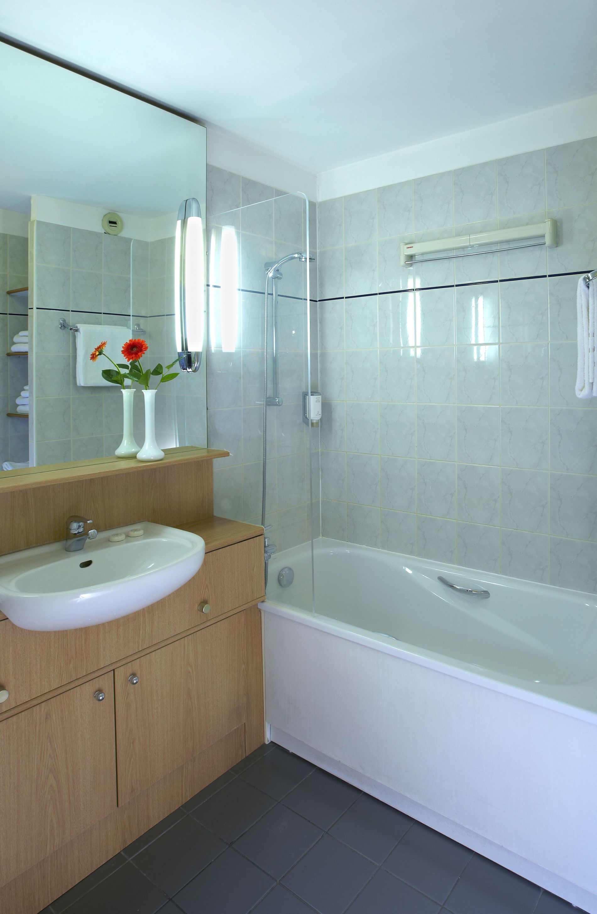 Salle de bain d'un Studio/Studio Deluxe équipée d'un combiné baignoire/douche et d'articles de toilette, appart hotel Paris 11