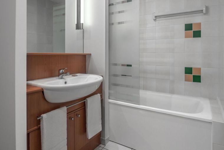 Cuarto de baño de un estudio equipado con bañera/ducha y toallas, apart hotel Paris 18