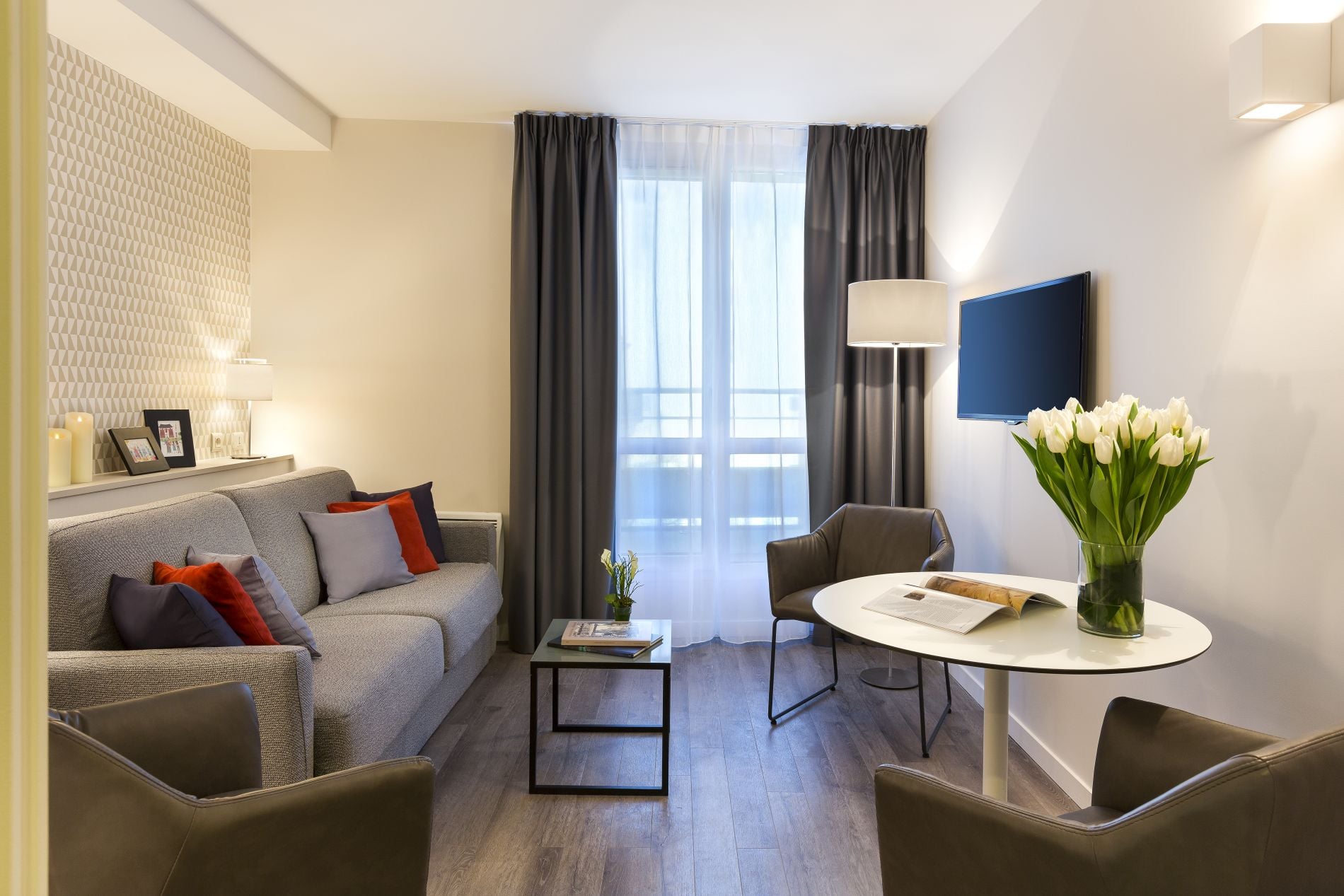 Salón de un Apartamento de un dormitorio con su sofá cama y su espacio de oficina, apart hotel Paris 18