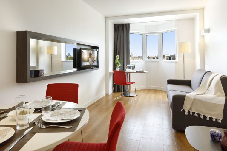 Living room of a 1-Bedroom Apartment equipped with a sofa bed, a dining area and a television, apart hotel Paris 14