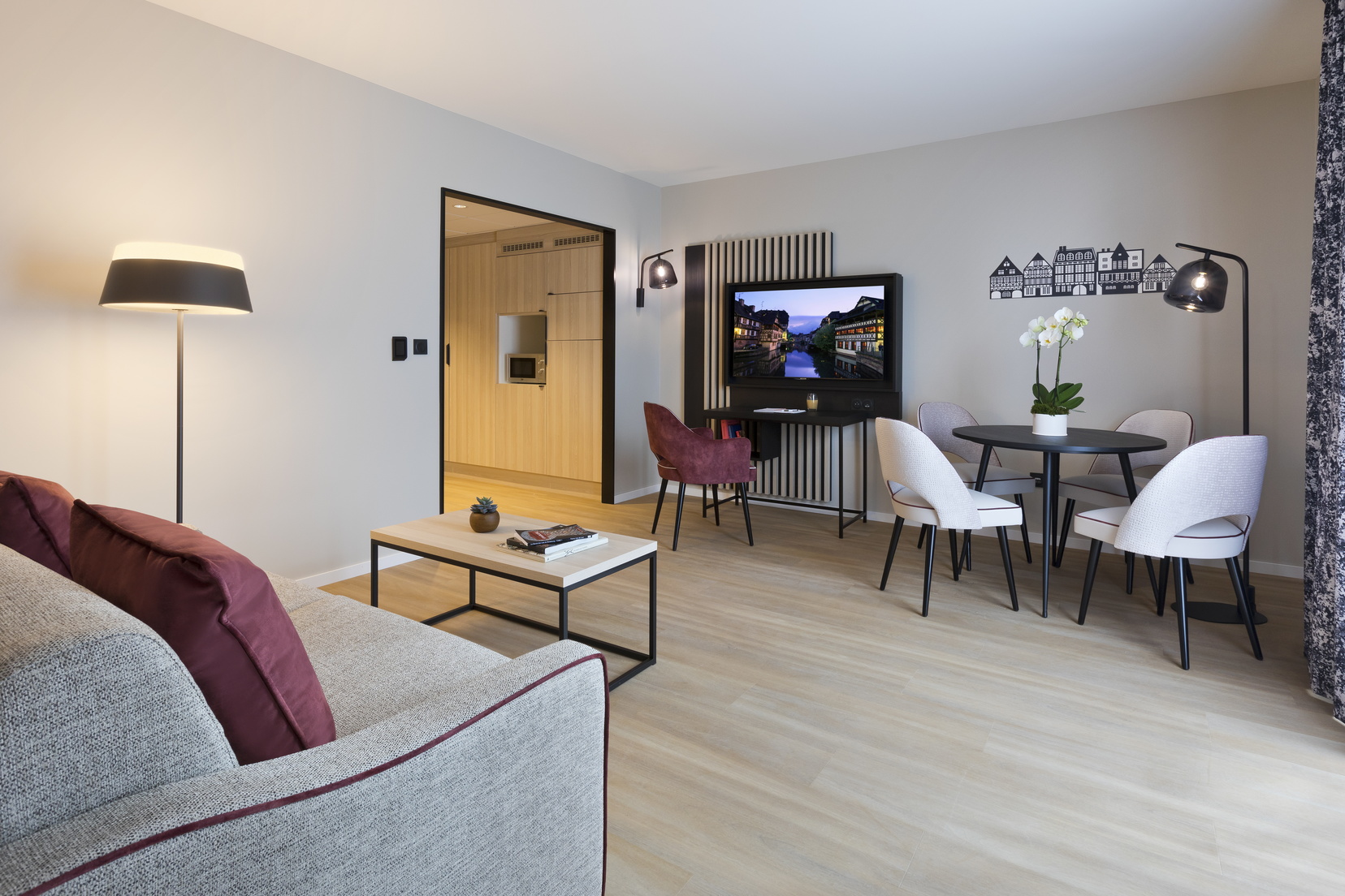 Wohnzimmer eines 2-Zimmer-Apartment mit Schlafsofa, Ess-/Schreibtischbereich und Fernseher, Wohnen auf Zeit in Straßburg