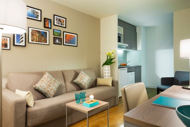 Sala de estar de un Apartamento de un dormitorio equipado con un sofá cama y una cocina, apart hotel Toulouse