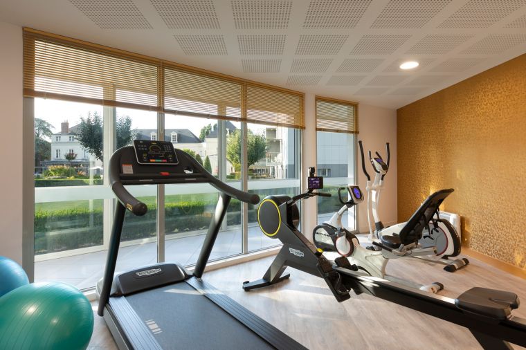 Espace fitness équipé de vélo elliptique, tapis de course et rameur, hôtel Tours