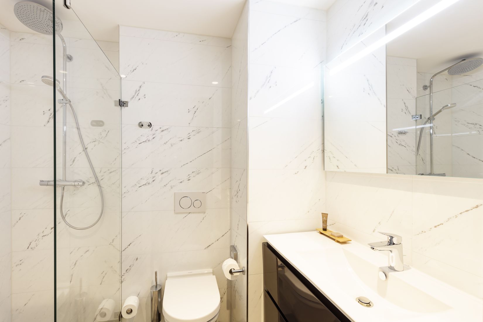 Cuarto de baño de un apartamento estudio con ducha y artículos de aseo, apart hotel Amsterdam