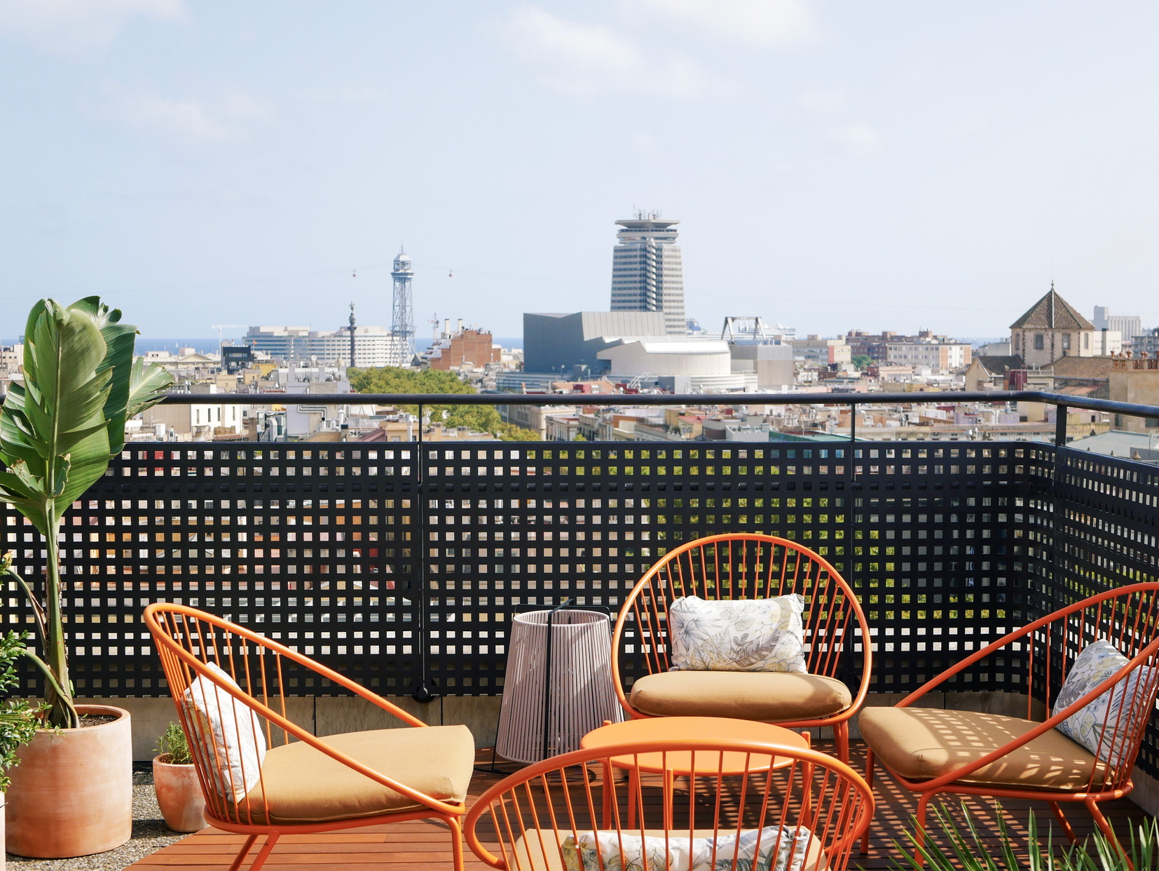 Terrasse avec chaises longues, canapés et des chaises en osier avec vue panoramique sur Barcelone, apart hotel Barcelona